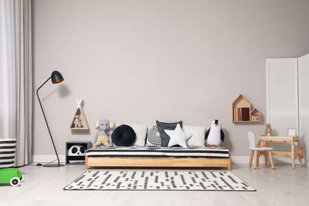 Cute kids room with stylish comfortable floor bed and toys. Montessori interiorの写真素材
