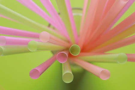 Different plastic straws on green background, above viewの写真素材