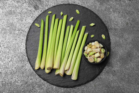 Fresh lemongrass stalks on gray table, top view
