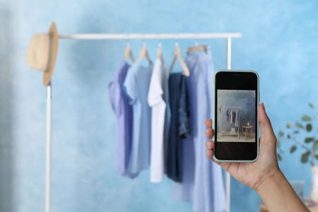 Blogger taking photo of stylish clothes indoors, closeup. Space for textの写真素材