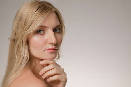 Portrait of young woman with beautiful face on beige background. Space for text