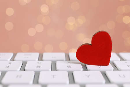 Red decorative heart on laptop keyboard, closeup. Online dating conceptの写真素材