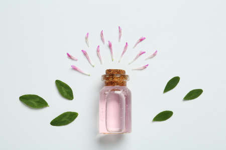Composition with essential oil, clover petals and leaves on white background, top viewの写真素材