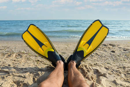 Man in flippers near sea on beach, closeupの写真素材