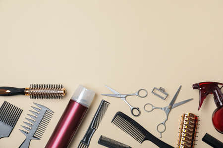 Flat lay composition of professional scissors and other hairdresser's equipment on beige background, space for text. Haircut toolの写真素材