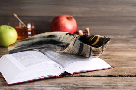 Shofar and open Torah book on wooden table. Rosh Hashanah holiday attributesの写真素材