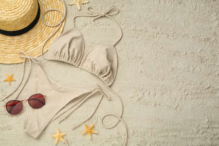 Flat lay composition with stylish bikini on sand. Space for textの写真素材