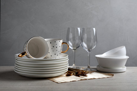 Set of clean dishware, glasses and cutlery on wooden tableの写真素材