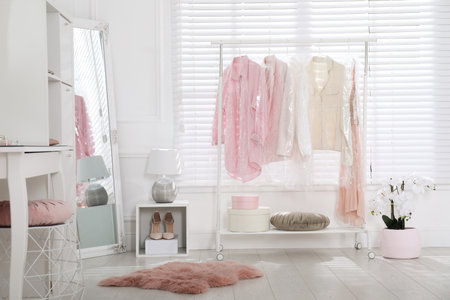 Rack with clothes in plastic bags indoorsの写真素材