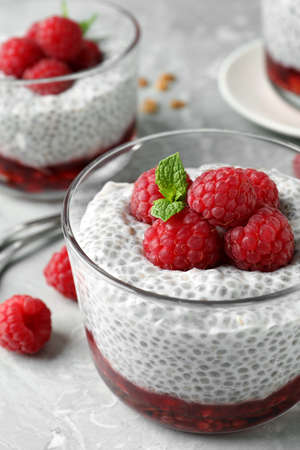 Delicious chia pudding with raspberries and mint on light marble table, closeupの写真素材