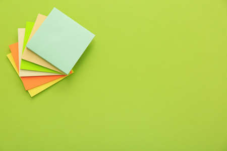 Stack of colorful stickers on light green background, top view. Space for text