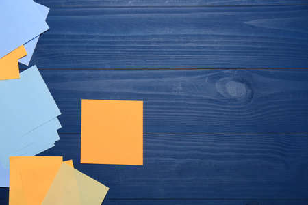 Colorful stickers on blue wooden table, flat lay. Space for text