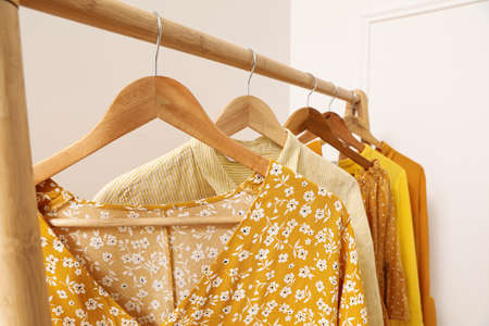 Wooden rack with hanging clothes indoors. Interior designの写真素材