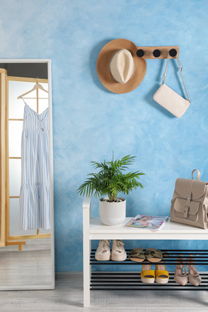 Stylish room interior with mirror, shoes and plant near light blue wallの写真素材