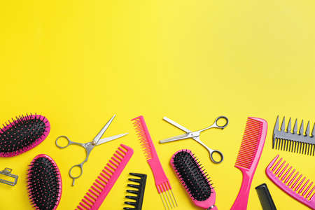 Flat lay composition with professional scissors and other hairdresser's equipment on yellow background, space for text. Haircut toolの写真素材