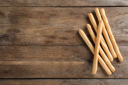 Delicious grissini sticks on wooden table, flat lay. Space for textの写真素材