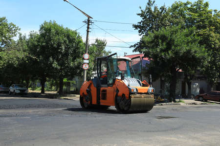 Roller working on city street. Road repairing