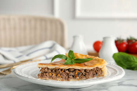 Piece of delicious pie with minced meat on table indoorsの写真素材