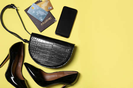 Flat lay composition with stylish woman's bag on yellow background. Space for textの写真素材