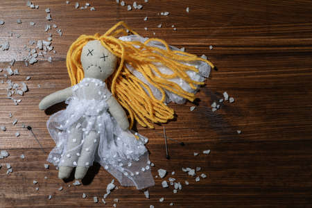 Bride voodoo doll with pins and salt on wooden background, flat layの写真素材