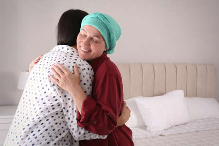 Young woman visiting her mother with cancer indoorsの写真素材