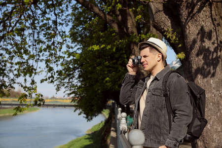 Tourist taking picture on city street near beautiful riverの写真素材