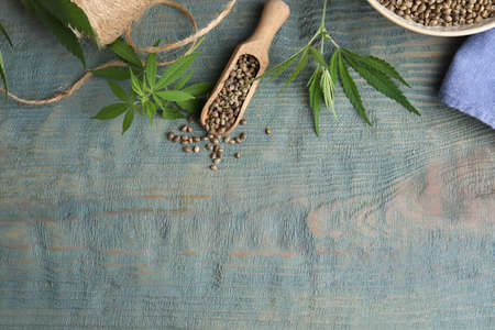 Flat lay composition with hemp seeds and leaves on light blue wooden table. Space for textの写真素材