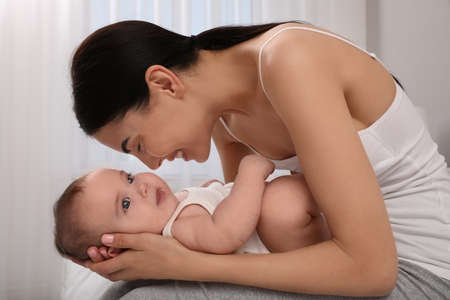 Young mother with her little baby at home