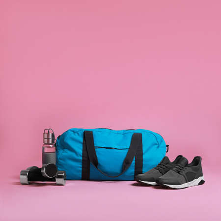 Blue gym bag and sports accessories on pink backgroundの写真素材