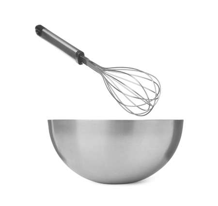 Metal balloon whisk and bowl on white backgroundの写真素材