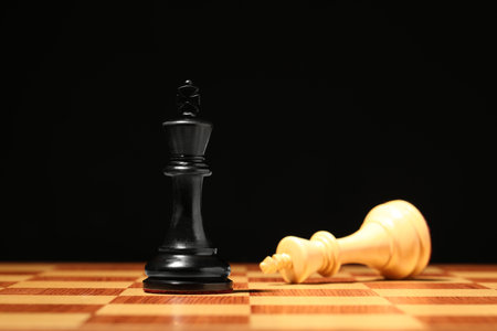 Chessboard with game pieces on black background