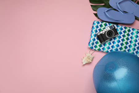 Flat lay composition with beach ball on pink background. Space for text
