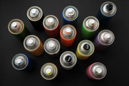 Cans of different graffiti spray paints on black background, flat layの写真素材