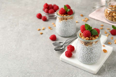 Delicious chia pudding with raspberries and granola on gray table. Space for textの写真素材