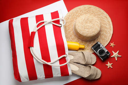 Stylish bag with beach accessories on color background, flat layの写真素材