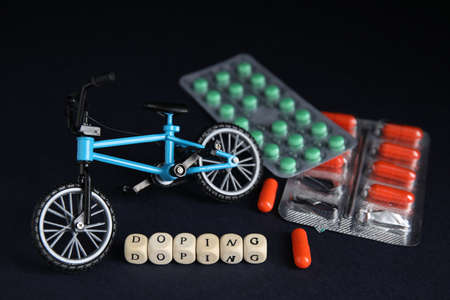 Word Doping, pills and bicycle model on black backgroundの写真素材