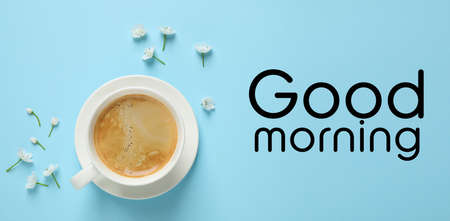 White flowers and coffee on light blue background, flat lay. Good morning