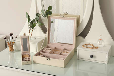 Jewelry boxes with stylish golden bijouterie on white dressing tableの写真素材