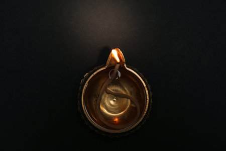 Lit diya on dark background, top view. Diwali lampの写真素材