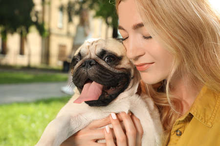 Woman with cute pug dog outdoors on sunny day, closeup. Animal adoptionの写真素材
