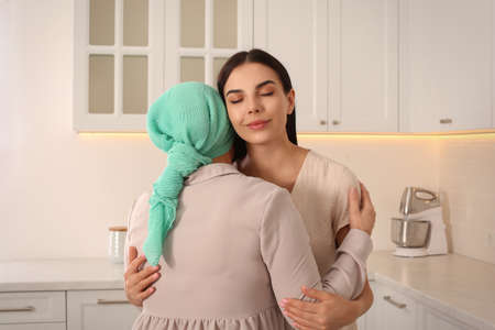 Young woman visiting her mother with cancer indoorsの写真素材