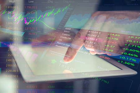 Stock exchange. Man using tablet and illustration of rating graphの写真素材