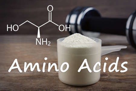 Measuring scoop of amino acids powder on wooden table, closeupの写真素材