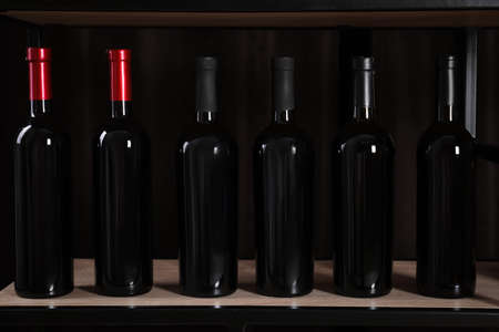 Bottles of wine on rack against black background