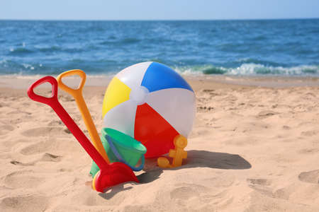Different sand toys and beach ball near seaの写真素材
