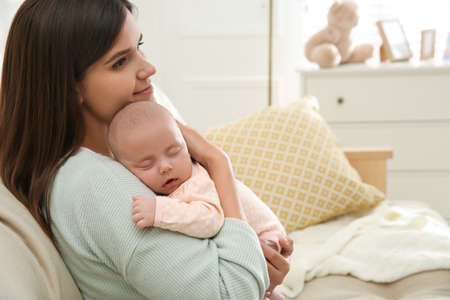 Mother holding her sleeping baby at home