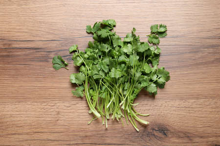 Bunch of fresh aromatic cilantro on wooden table, top viewの写真素材