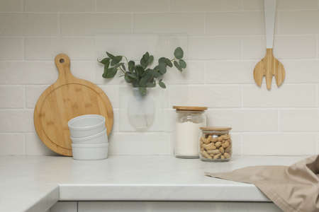Silicone vase with eucalyptus branches on wall over countertop in kitchenの写真素材