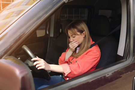 Young woman suffering from nausea in car