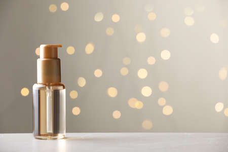 Skin care product on light table against blurred lights, space for textの写真素材